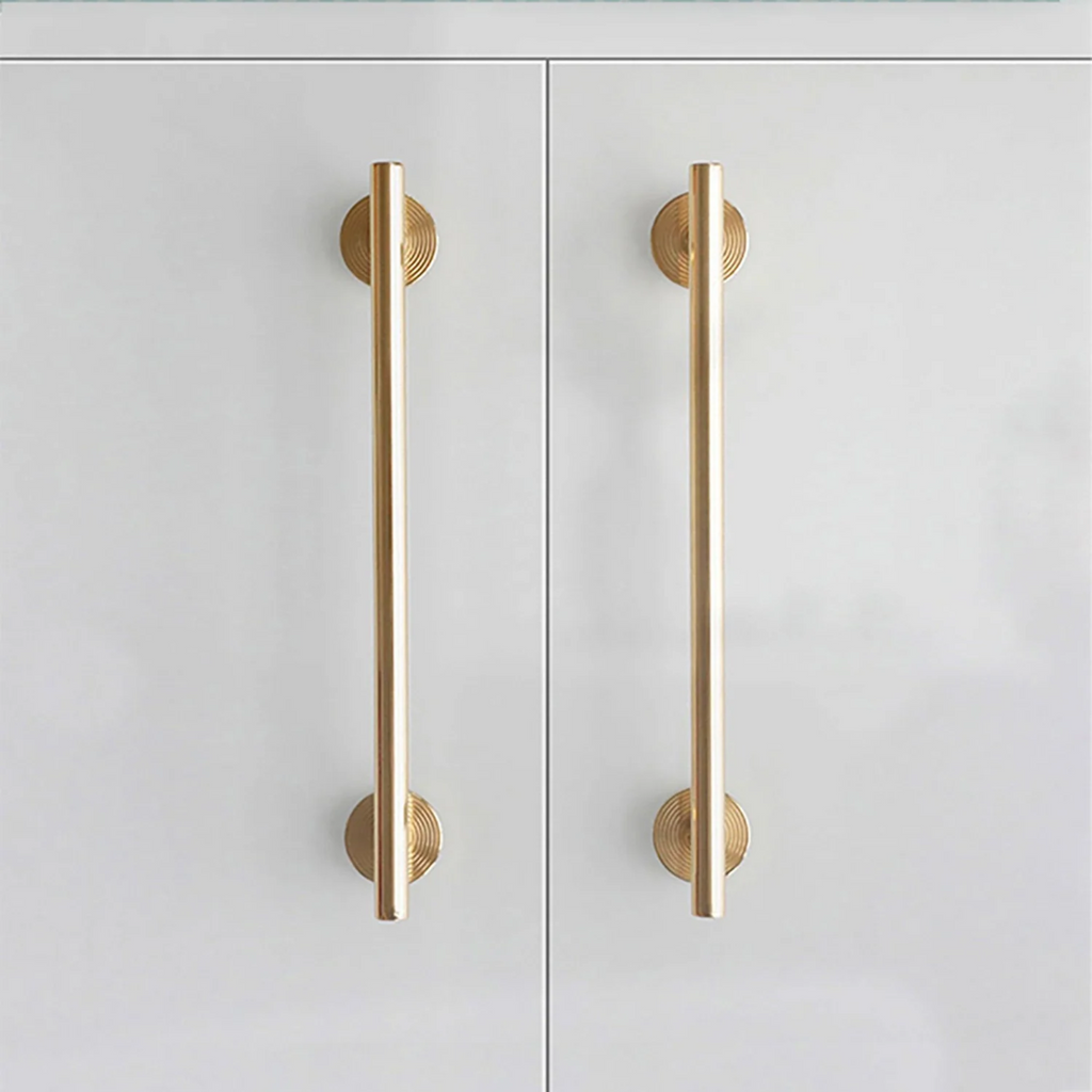 Minimalist brass concentric ring handles by Brass Essence, showing close-up of sleek, modern design with circular shapes and polished finish.