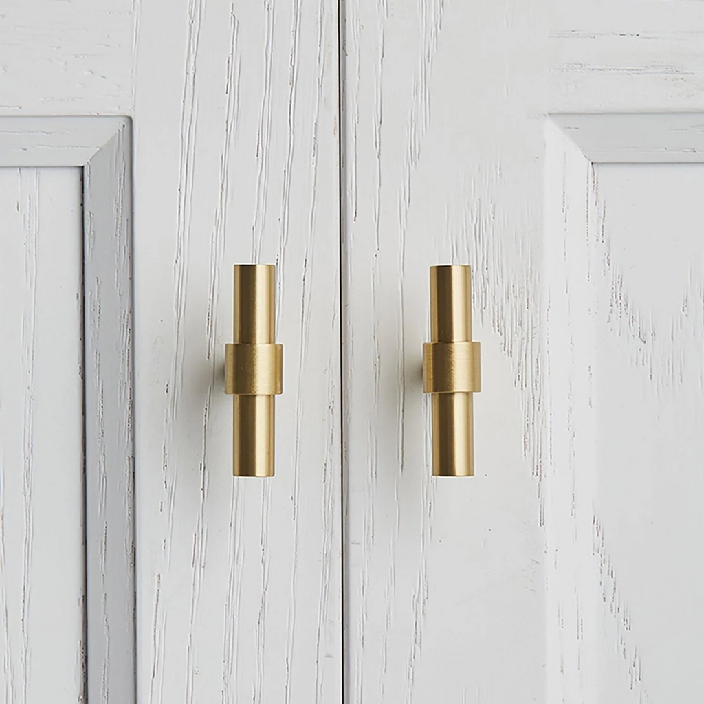 Brass Essence Naveena solid brass T-bar handle from the collection, showing a polished T-shaped handle on a plain background.