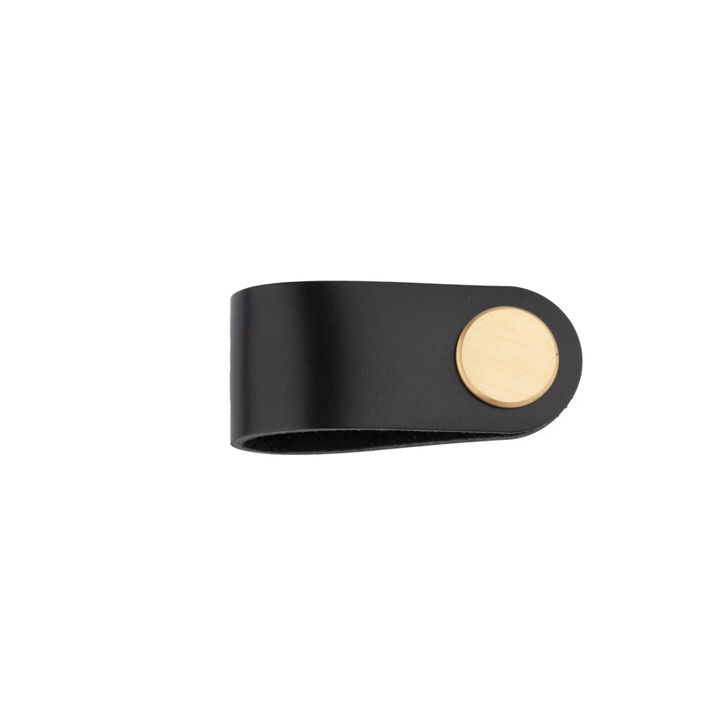 Brass essence leather and brass strap cabinet pull handle mounted on a wooden drawer, showcasing a sleek, modern design.