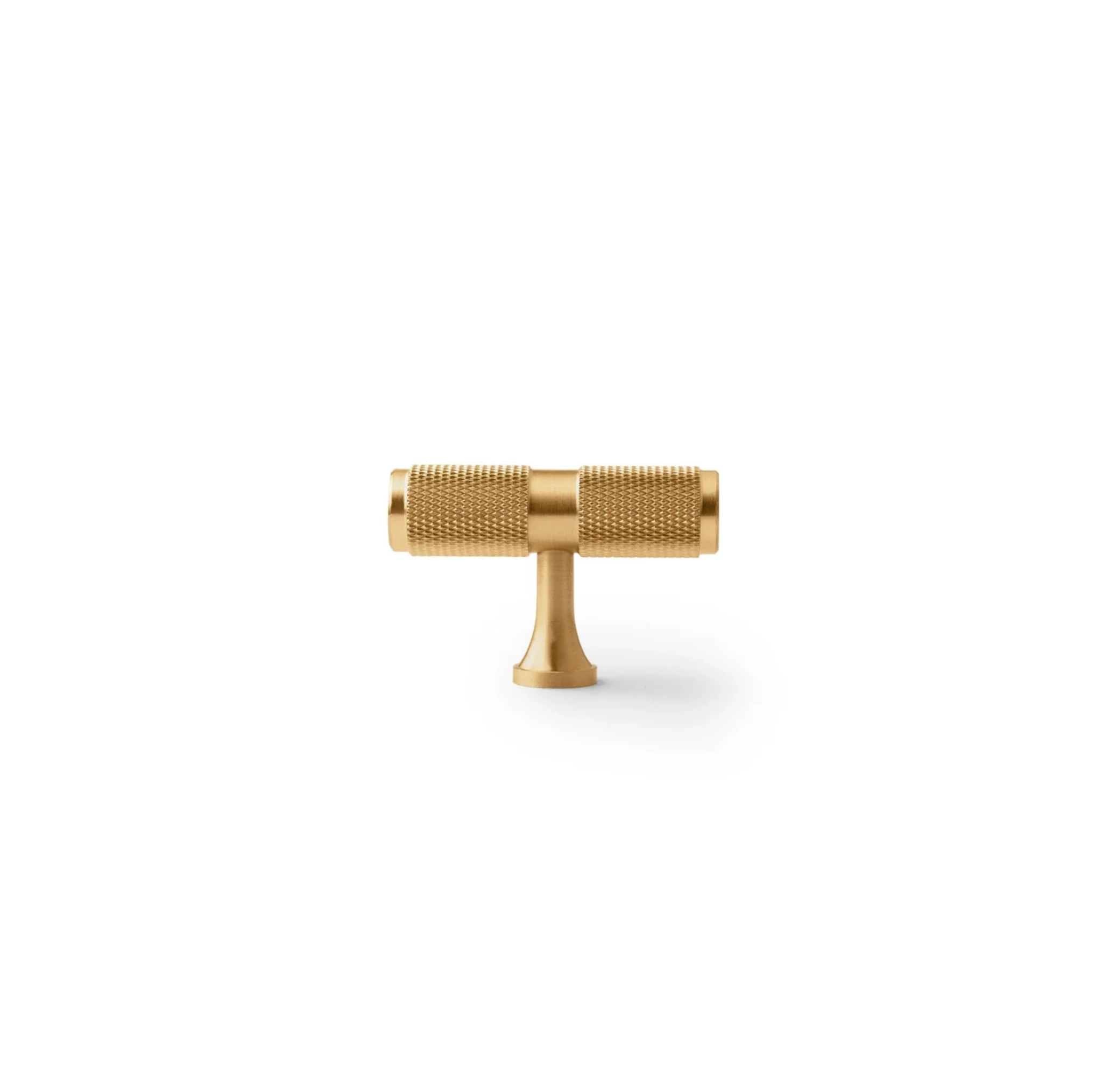 Yashvite knurled brass cabinet handle from Brass Essence collection, showing a close-up of the textured, polished brass handle on a cabinet door.