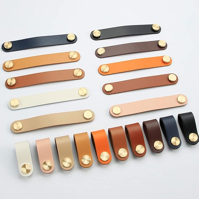 Brass Essence leather and brass strap cabinet pull, showing close-up of black leather strap with brass hardware for furniture drawers