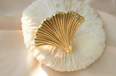 Brass Essence polished gold ginkgo leaf cabinet pull with detailed leaf design on a wooden cabinet handle.