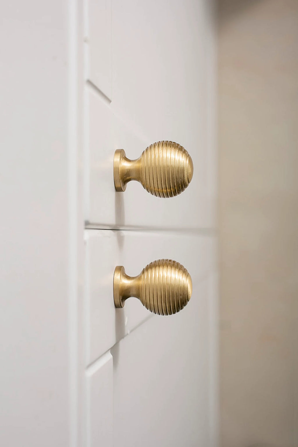 Brass Essence Alexander & Wicks brass knob with luxurious brushed finish, close-up of round decorative hardware for furniture.