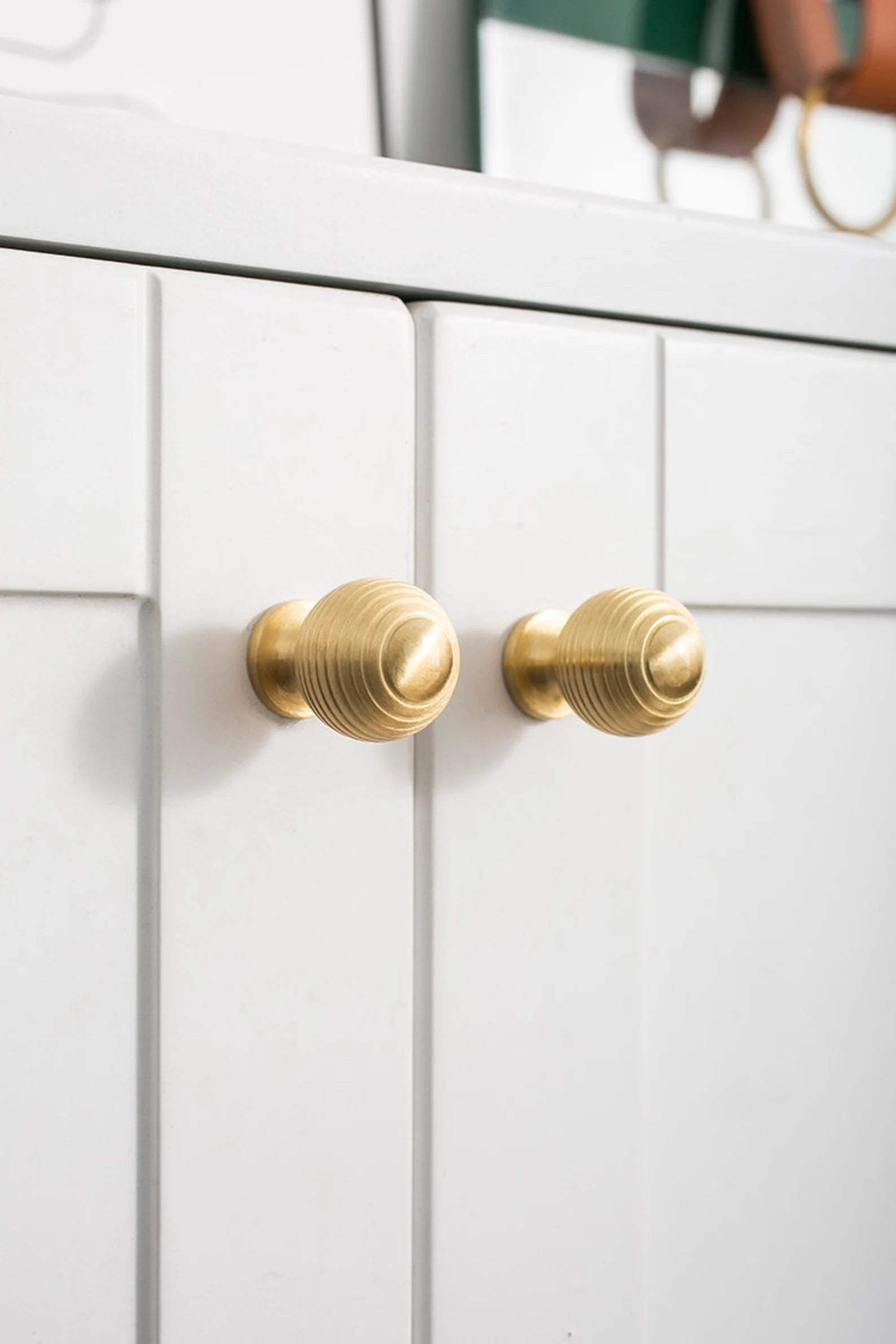 Brass essence Alexander & Wicks brass knob with luxury brushed finish, close-up of polished round hardware for furniture.